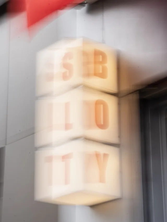 L'enseigne lumineuse SLT BOY de la boutique, en flou artistique.