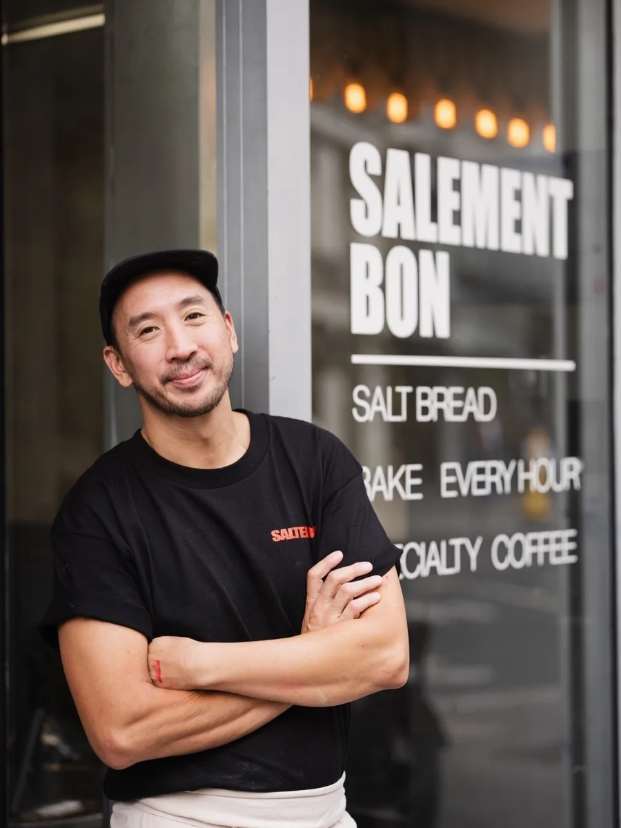 Le boulanger bras croisés devant la vitrine — Salement bon, salt bread, bake every hour.